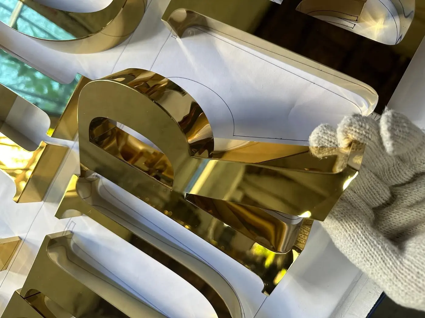 Golden stainless steel signage letters in production