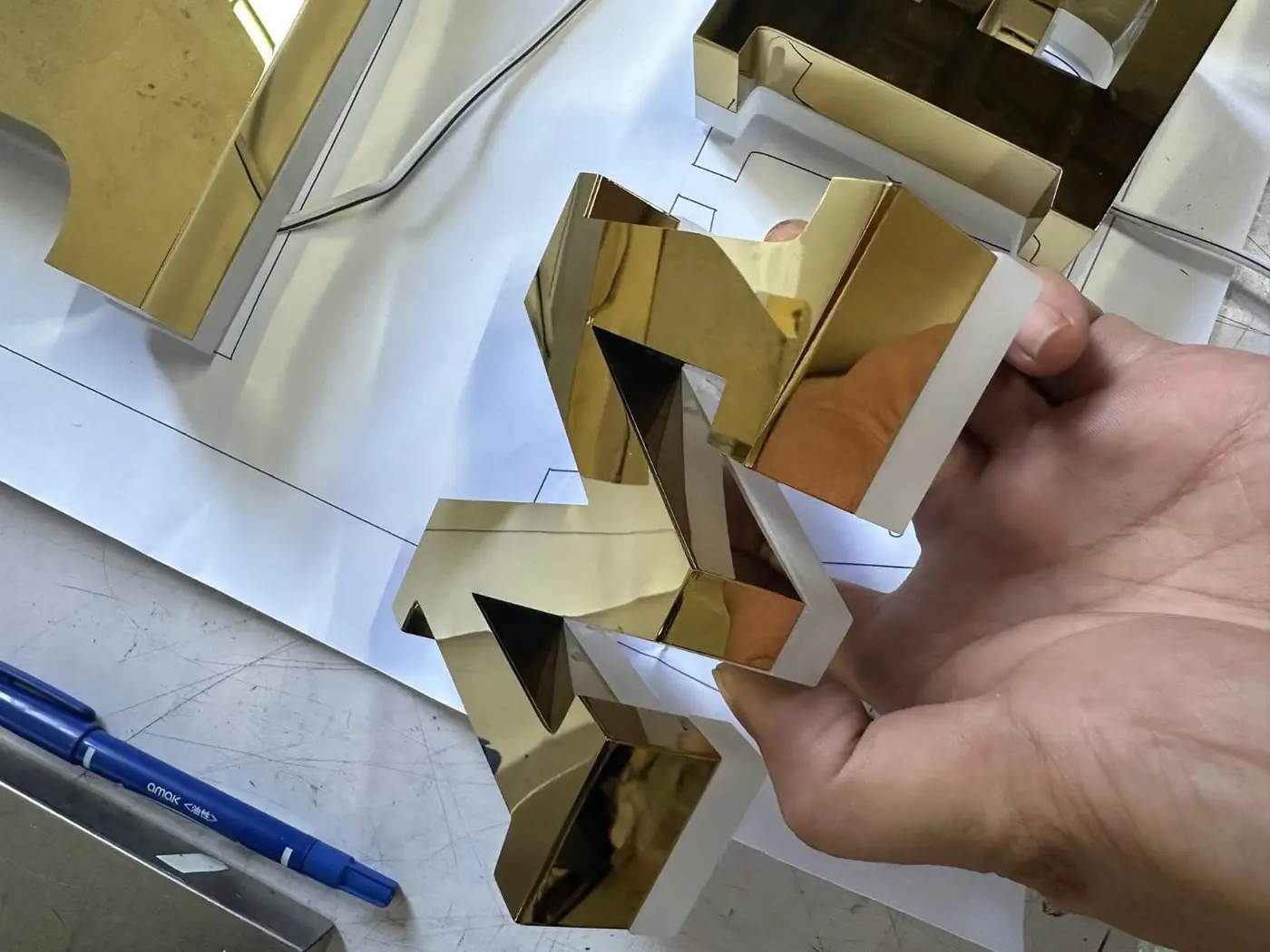 Golden metal signage letters in hand
